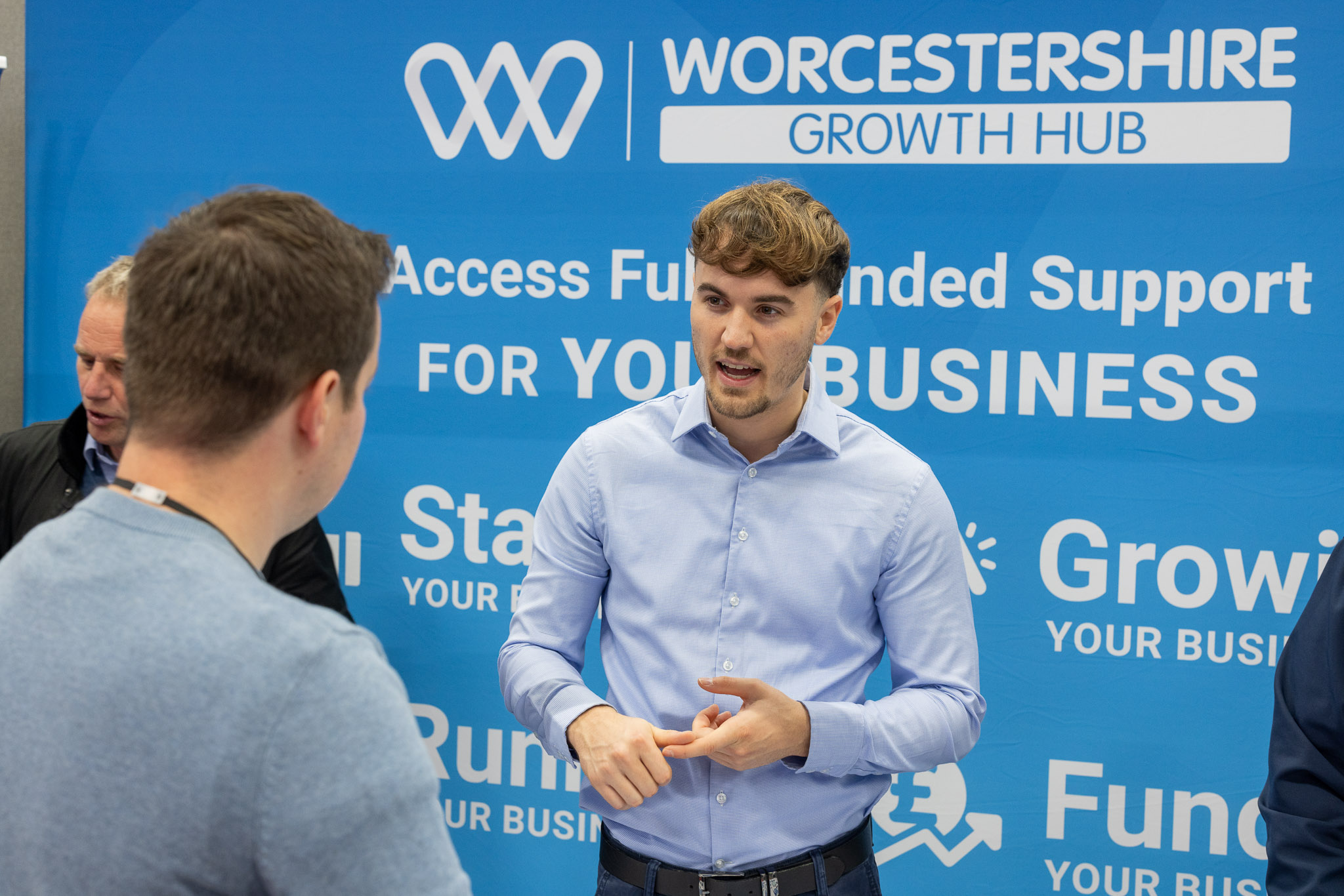 two men in building yard with hard hats, shaking hands