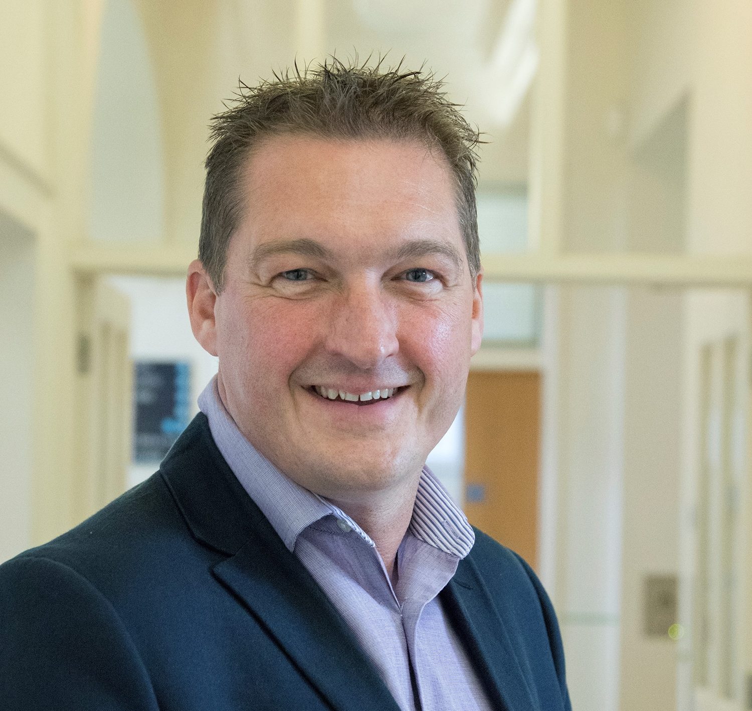 Dr Scott Andrews two men in building yard with hard hats, shaking hands